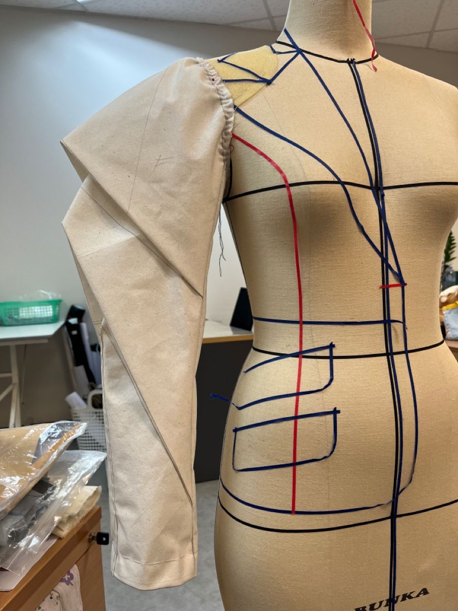 Maniquí con una pieza en construcción: manga de toile y líneas de patronaje